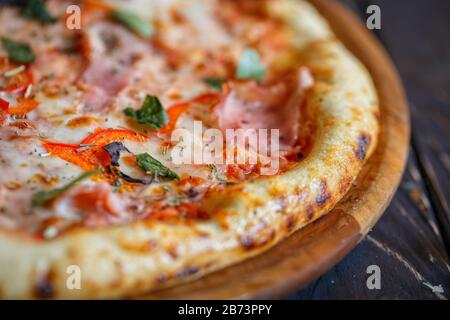 Macro photo of pizza with ham, tomato and basil. selective focus Stock Photo