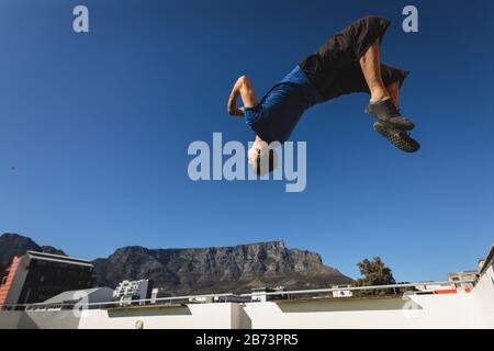 Caucasian man practicing parkour and doing a somersault Stock Photo