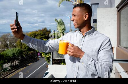 Man using his phone and drinking coffee Stock Photo