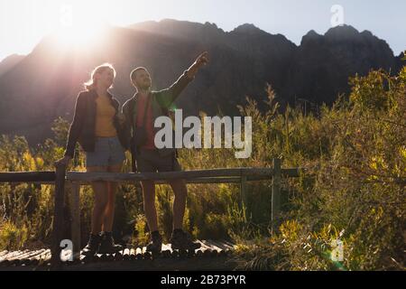 Front view of couple with backpacks on a wooden bridge Stock Photo
