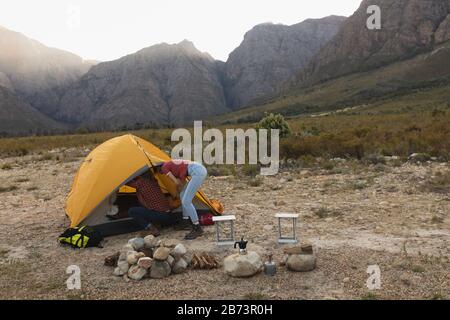 Side view of couple looking inside of their tent Stock Photo