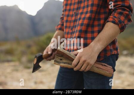 Mid section view of man holding wood and a ax Stock Photo