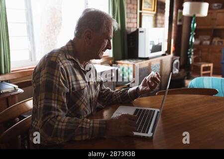 Senior man using laptop at home Stock Photo