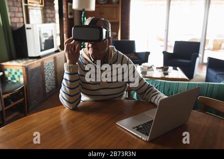 Senior man using virtual reality headset at home Stock Photo