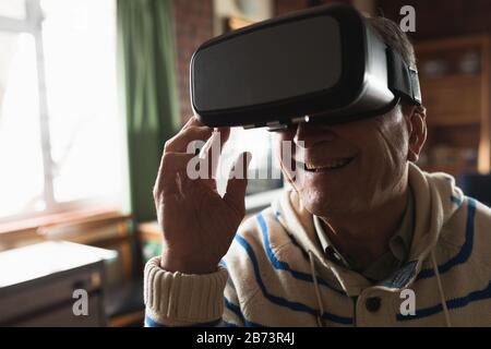 Senior man using virtual reality headset at home Stock Photo