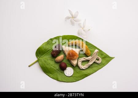 Hindu Puja with betel leaf, supari, janeu, almond, dates, turmeric, dried coconut and jaggery with 1 rupee coin. Important item in Vedic rituals. sele Stock Photo