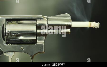 Cigarette fire in gun muzzle compared smoking can kills Stock Photo