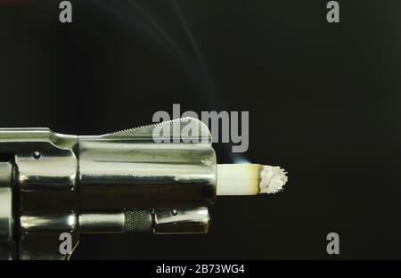 Cigarette fire in gun muzzle compared smoking can kills Stock Photo