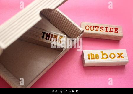 Think outside the box words on wooden blocks on pink background, innovation marketing concept Stock Photo