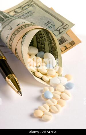 Medicines coming out of a roll of dollar notes Stock Photo