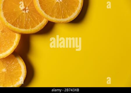 orange fruit slices on yellow background with copy space. top view Stock Photo