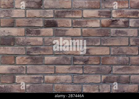 Brick wall with variegated brown bricks. Used as a background. Copy space for your text. Stock Photo