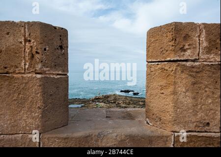 View throug the city walls of Essaouira, Morocco towards the Atlantic Ocean Stock Photo