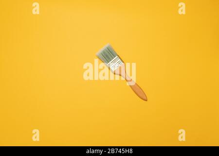 Wooden painter's brush on a yellow background, top view, flat lay style Stock Photo