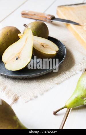 still life, green pears in a metal plate on a white wooden table Stock Photo