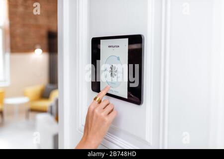 Controlling home ventilation or conditioning with a digital touch screen panel. Concept of wireless ventilation control and smart home Stock Photo