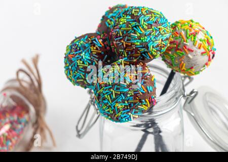 A colorful cake pops up, lying on a table. It is covered with sweet multi-colored sweets. Copy space Stock Photo