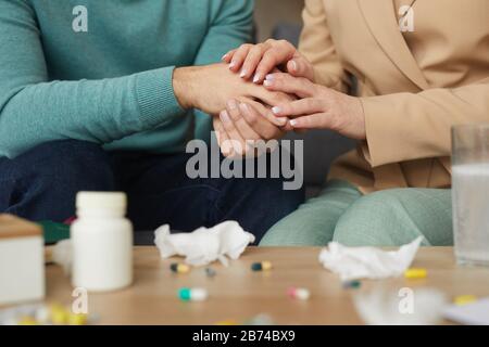 Close-up of couple sitting on sofa and holding hands they supporting each other in difficult situation Stock Photo