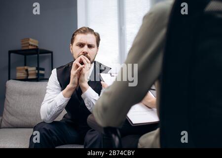 Patient sitting on couch during psychologist's consultation Stock Photo