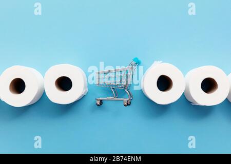 Roll of white toilet paper with a shopping cart on a blue background Stock Photo