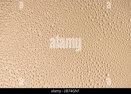 Close up photo of little water drops with contour shadow isolated on beige color background Stock Photo