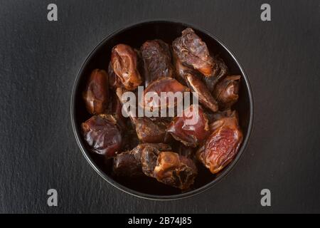 A studio photograph of a bowl of pitted dates Stock Photo