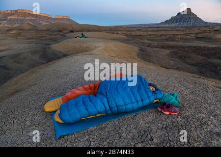 Mylène Jacquemart and Robert Hahn camp in the badlands of Factory Butte Recreation Area near Caineville, Utah. Stock Photo