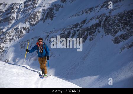 Man in blue jacket ski touring Stock Photo
