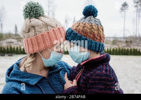 mother and son looking at each other with face masks for protection Stock Photo