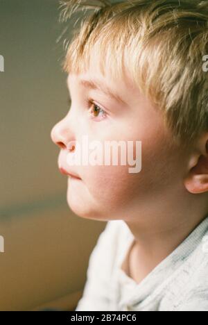 Little boy looking out the window, captured on film.