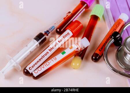 COVID-19 Laboratory table with medical test tube with blood for atypical pneumonia virus phonendoscope, mask and gloves Stock Photo