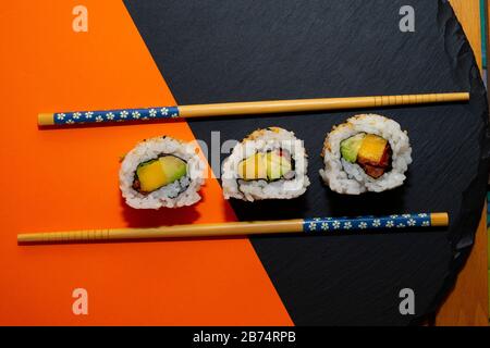 Pieces of vegetarian sushi on an orange background. Vegetarian sushi concept. Stock Photo