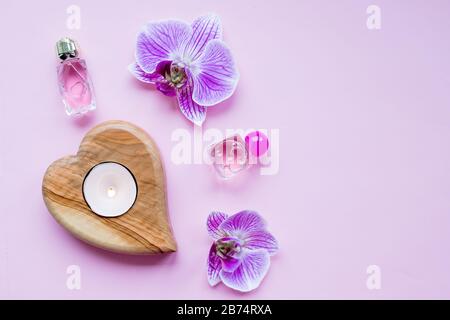 Beauty blog concept. Accessories, flowers, cosmetics and candle on pink background, copyspace. Womens Day concept. Stock Photo