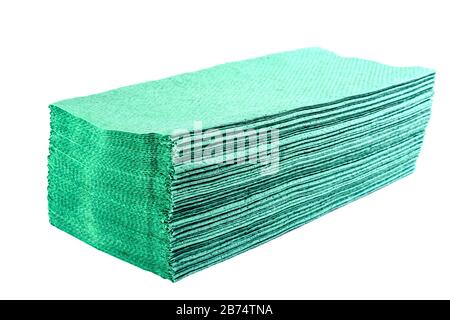Stack of green disposable hygienic paper towels or napkins for use in bathroom or kitchen. Selective focus. Isolated on white background. Close-up. Stock Photo