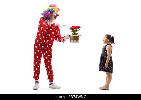 Full length shot of a clown making flowers appear from a hat and a surprised little girl watching isolated on white background Stock Photo