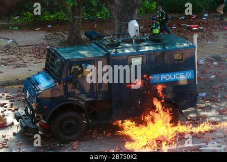 Molokov cocktail throw by protesters explode on a police armor vehicle.  Protesters clash with police at the Hong Kong Polytechnic University. Stock Photo