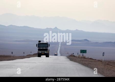 Trucks on a highway through the desert near Chupanan, Iran. [automated translation] Stock Photo