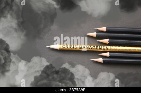 Crisis Management written on pencil composition against heavy clouds. Crisis management or risk assets concept Stock Photo
