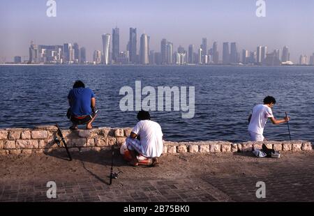 13.09.2010, Doha, Qatar (Qatar) - Men fishing on the promenade along Al Corniche Street with a view of the skyline of the Al Dafna business district in the background. [automated translation] Stock Photo