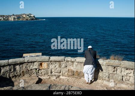 21.09.2018, Sydney, New South Wales, Australia - A Muslim tourist stands at Mackenzies Point along the coastal hiking trail between Bondi and Bronte and looks out to sea. [automated translation] Stock Photo
