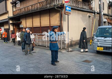 23.12.2017, Kyoto, Japan, Asia - A traffic supervisor regulates the traffic at an intersection in the old town of Kyoto. [automated translation] Stock Photo