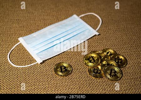 Gold Bitcoin coins with a medical mask. A business finance concept Stock Photo