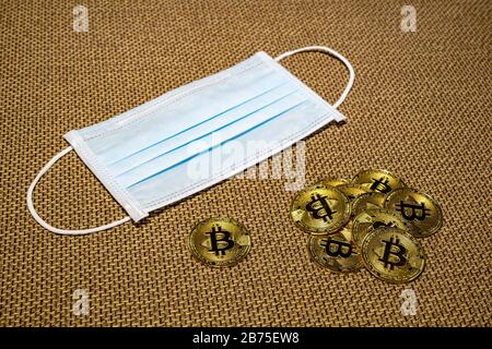 Gold Bitcoin coins with a medical mask. A business finance concept Stock Photo