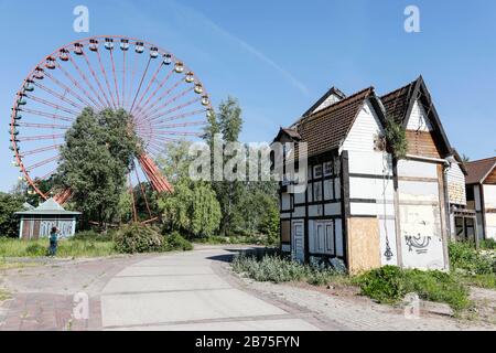 View of the rusting Ferris wheel in the former Spreepark in the Berlin Plaenterwald, in the foreground are dummies of houses. In GDR times the playground was a well visited amusement park. Gruen Berlin GmbH will redesign the park. [automated translation] Stock Photo