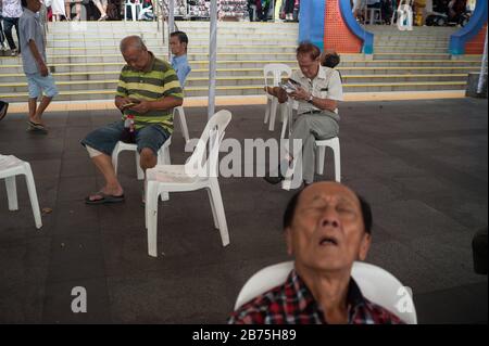 11.03.2018, Singapore, Republic of Singapore, Asia - A group of elderly men are sitting in Crete Ayer Square in Singapore's Chinatown district. [automated translation] Stock Photo