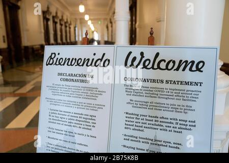 Texas, USA. 13th March, 2020. Bilingual signs warning of coronavirus greet visitors at the Texas Capitol in Austin, where Gov. Greg Abbott held a press conference earlier declaring a statewide 'state of disaster' while Texas braces for an onslaught of coronavirus cases. Credit: Bob Daemmrich/Alamy Live News Stock Photo