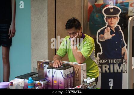 19.11.2017, Singapore, Republic of Singapore, Asia - A man sells mulberry drinks in front of a shopping mall in Chinatown with a cardboard warning sign at its entrance. [automated translation] Stock Photo