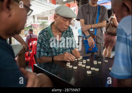 29.09.2017, Singapore, Republic of Singapore, Asia - Older men play Chinese chess, also called Xiangqi, on a public square next to the Buddha Tooth Relic Temple in Singapore's Chinatown district. Often, smaller amounts of money are involved. [automated translation] Stock Photo