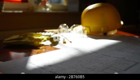 Engineer or construction manager office. Building and construction background concept. Scheme, helmet and build tools on the desk. Stock Photo
