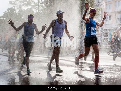 Participants in the 43rd Berlin Marathon in the Schoeneberg district of Berlin will be cooled off with a water shower. 41,283 runners participated in the marathon. [automated translation] Stock Photo